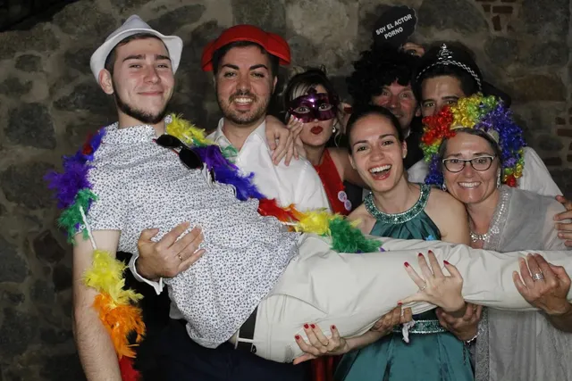 Invitados con atrezzo levantando en brazos a un amigo durante la fiesta